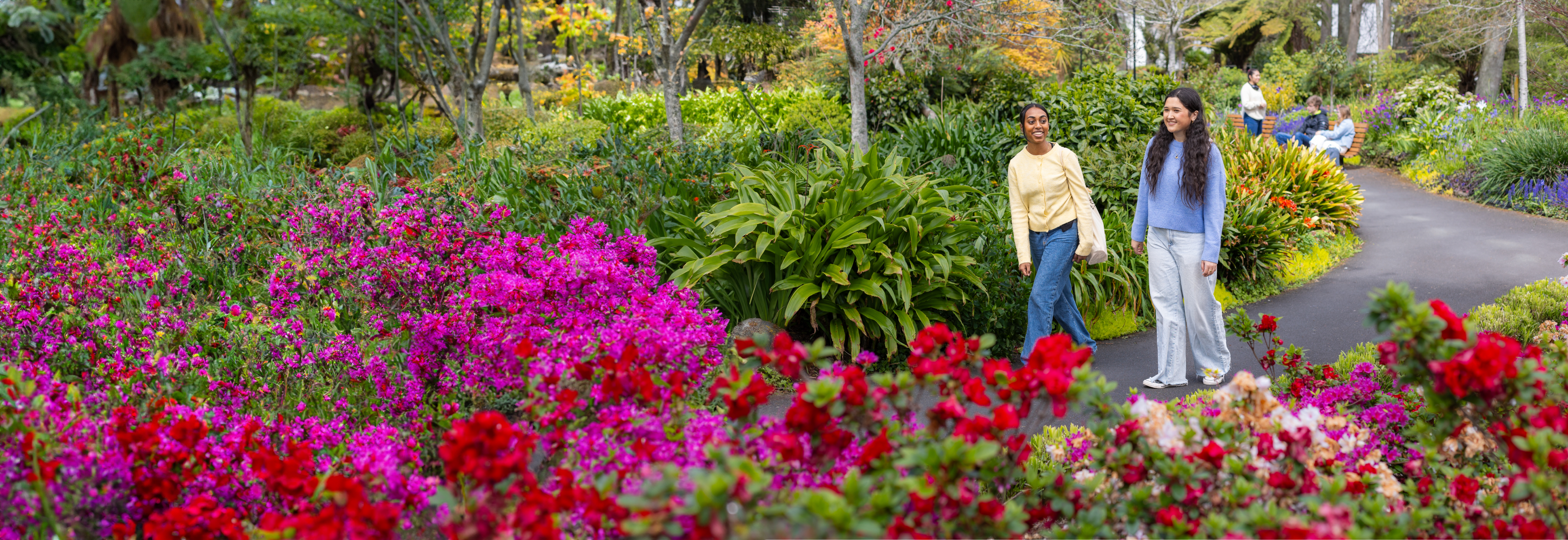 students-walking-past-garden-flowers