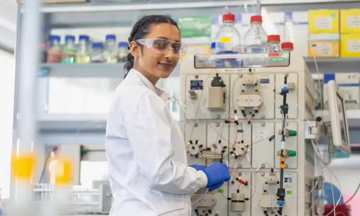 student-smiling-using-lab-equipment