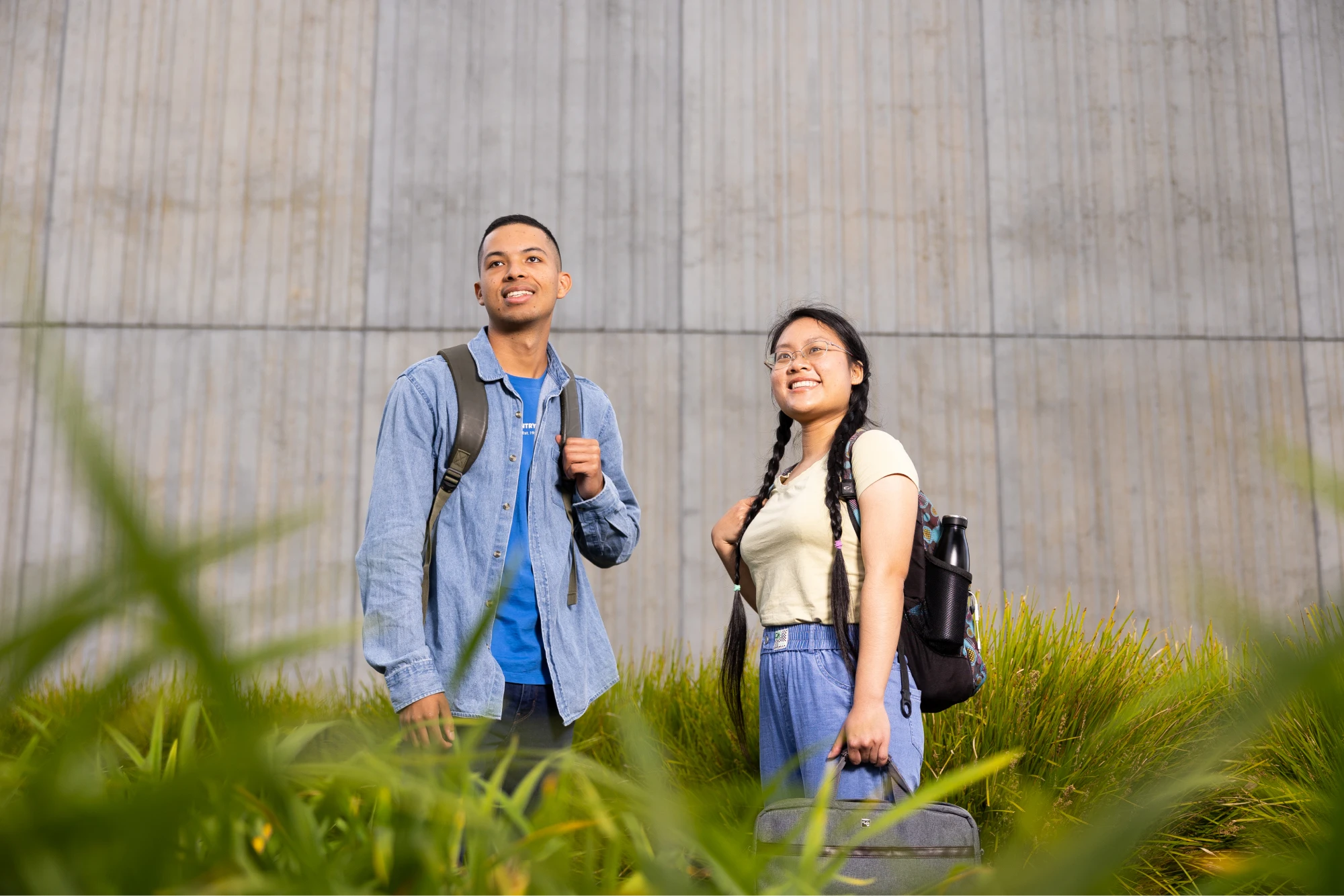 two-students-outside-looking-into-distance