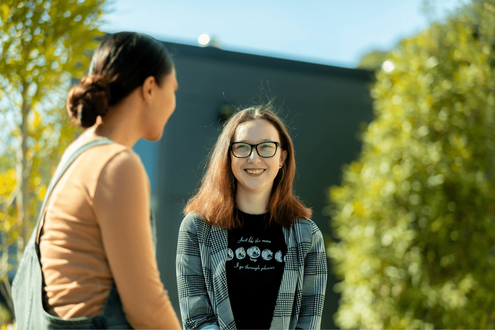 two students sitting outside talking